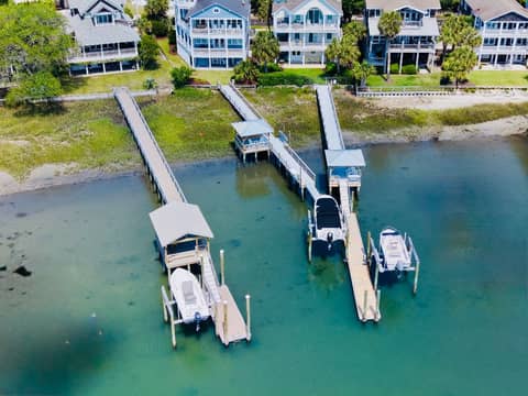 Aerial view of dual residential docks with covered boathouses and boat lifts