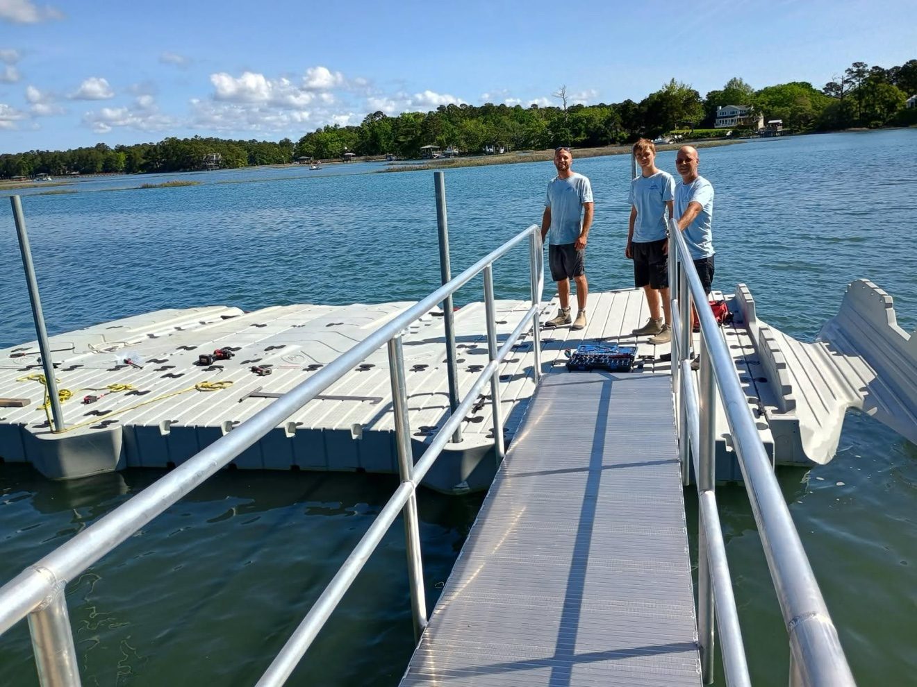 Mark Lipe and his two sons standing on a newly installed floating dock with an aluminum gangway